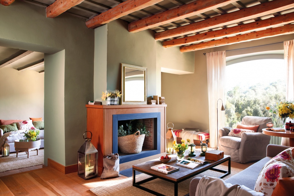 Оливковая гостиная с ярким камином в испанском доме