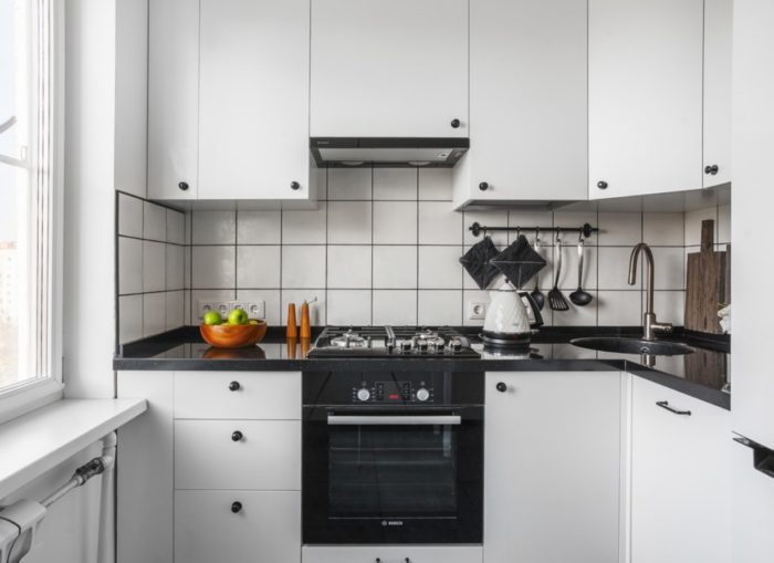 Черная духовка в белом кухонном гарнитуре