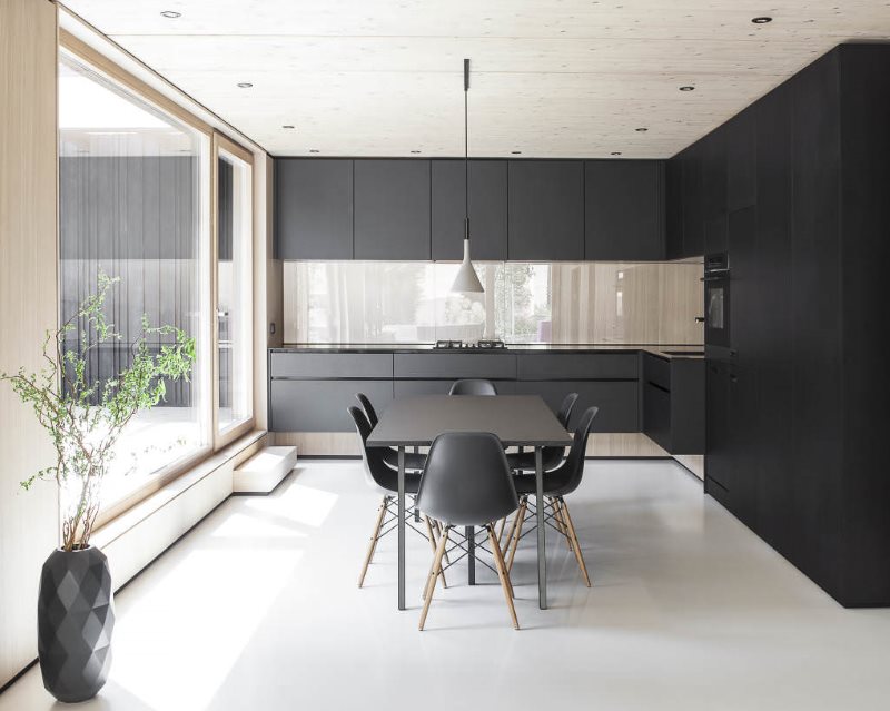 Угловой гарнитур черного цвета на кухне в стиле минимализма