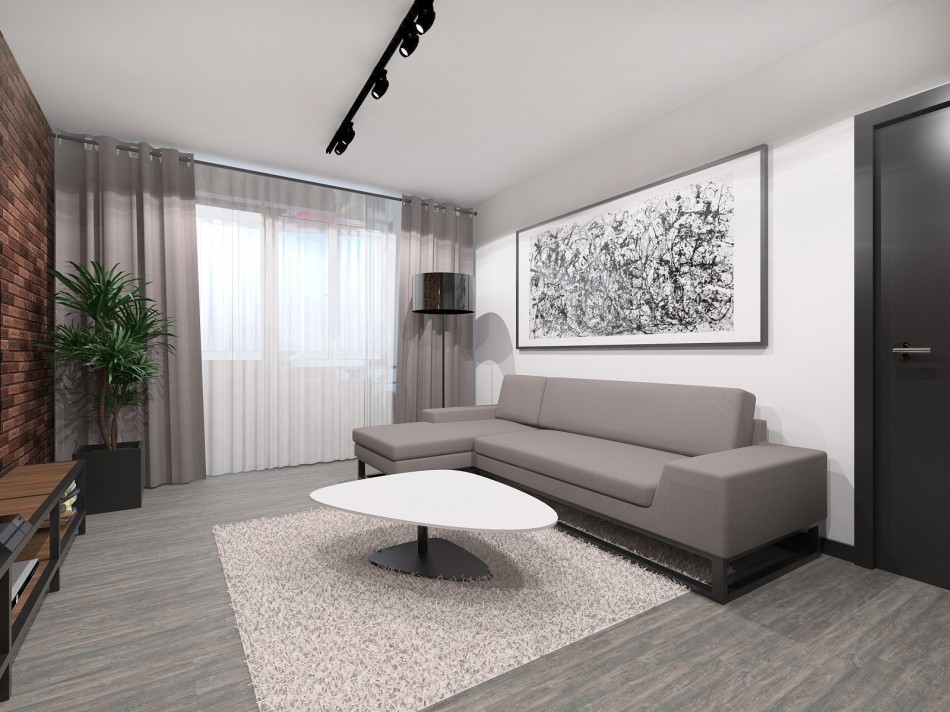 Серый диван на фоне белой стены в однокомнатной квартире