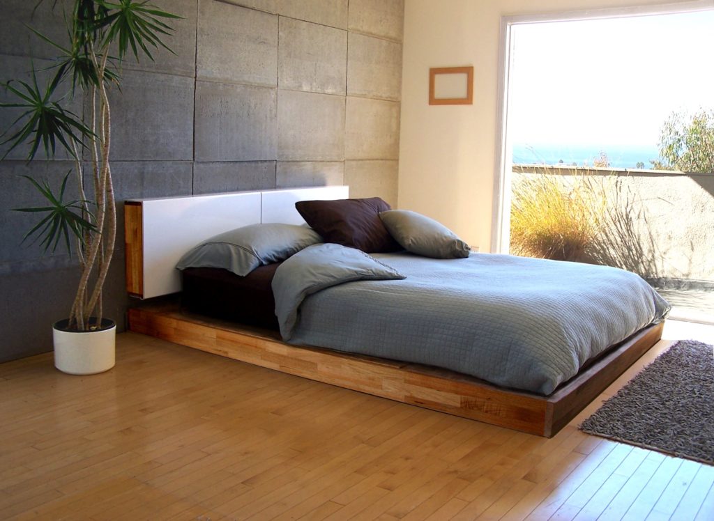 Кровать на низком подиуме в интерьере спальной комнаты
