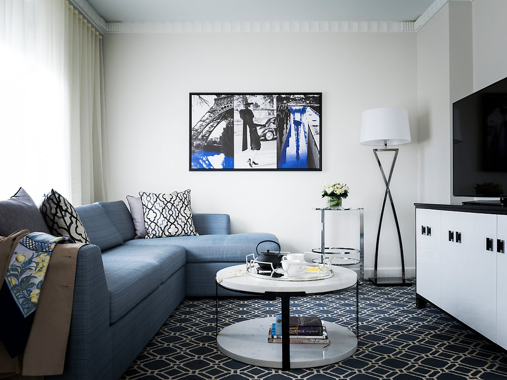 Синий угловой диван в черно-белой гостиной