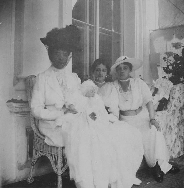 Вдовствующая императрица Мария Фёдоровна держит на руках маленькую правнучку Ирину, рядом сидят дочь вдовствующей императрицы Ксения Александровна и внучка Ирина Александровна