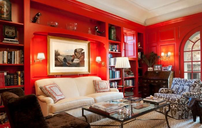 Белый диван на фоне красных стен в гостиной комнате