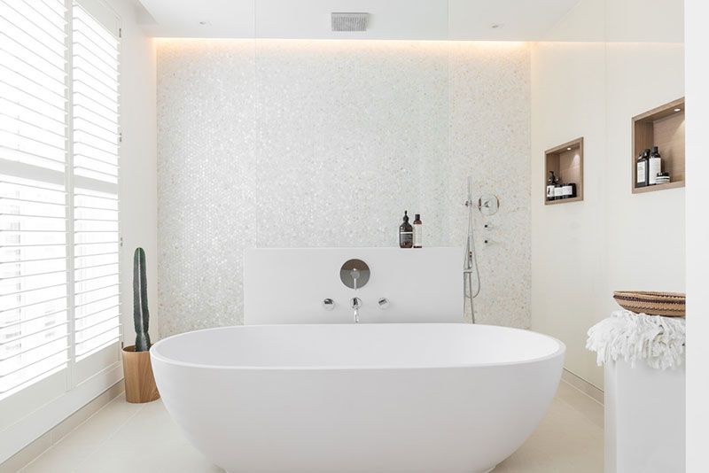 Выделенная белоснежной мозаикой стена в ванной комнате