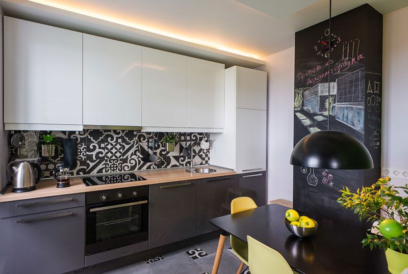 Черно-белый дизайн кухонного пространства подчеркнуто выразителен благодаря настенной и напольной плитке